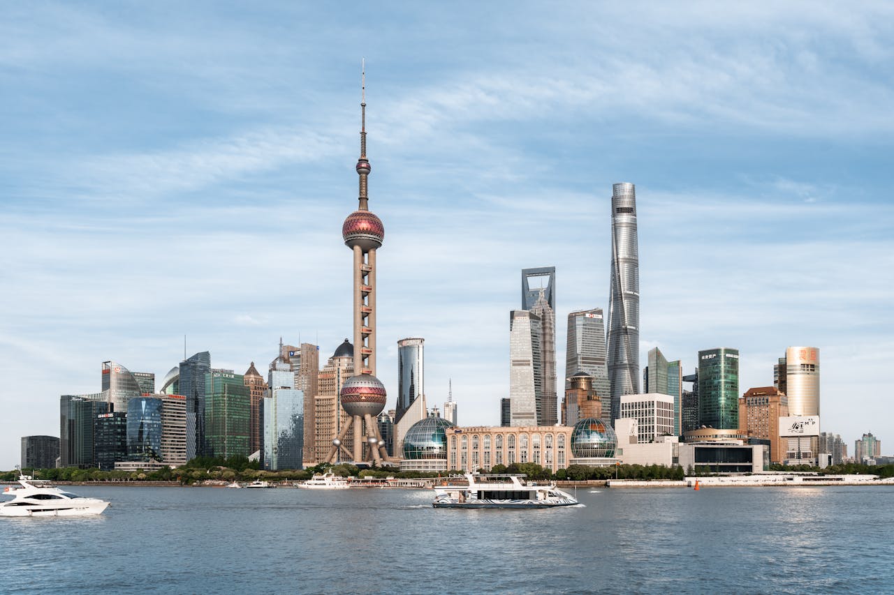 Becas en China: una puerta abierta para jóvenes latinoamericanos View of Shanghai skyline with the iconic Oriental Pearl Tower and modern skyscrapers from the river.